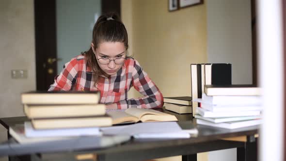 camera moves outside the window, showing girl who is preparing for exams