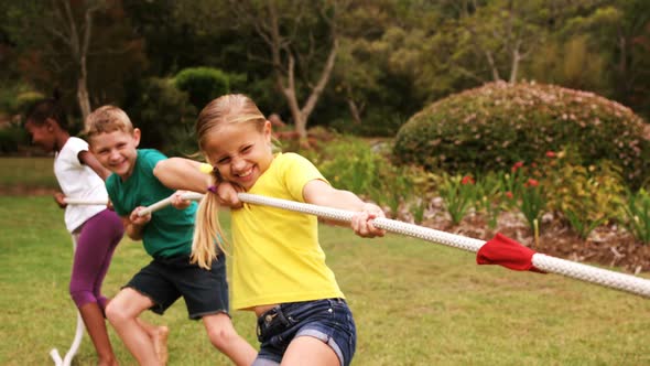 Kids playing tug of war in park