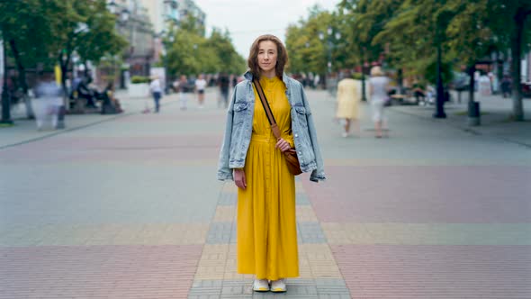 Time Lapse of Attractive Young Woman Standing in City Center in Pedestrian Street Looking at Camera