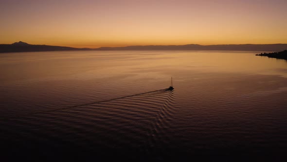 Aerial shot overtaking sailboat on Lake Léman with beautiful sunset colorsIn front of Cully, Lavaux