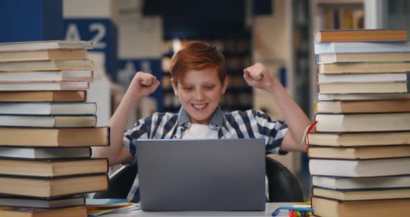 Teen Boy Student Feeling Happy After Accomplishing Task Sitting in Library