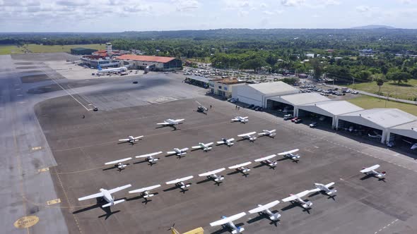 Large number of light aircraft parked on tarmac, Cibao Airport; aerial