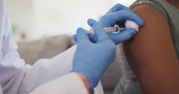 Close up of african american girl and caucasian female doctor vaccinating