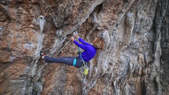 Slow Motion Smiling Tired Woman Rock Climber Hanging on Rope on Hard Challenge Route on Overhanging