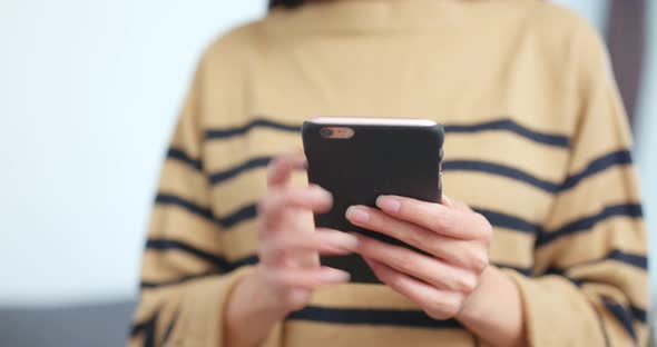 Woman using smart phone at home