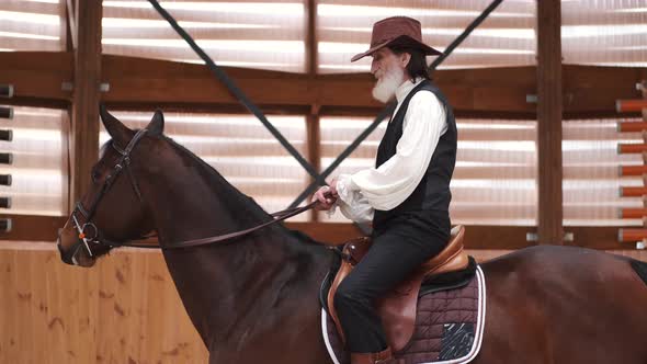 Old Cowboy in a Hat Riding a Horse