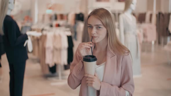 Beautiful Woman Drinking Coffee in Clothes Store