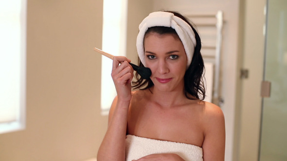 Beautiful Brunette Wearing A Towel Using Makeup