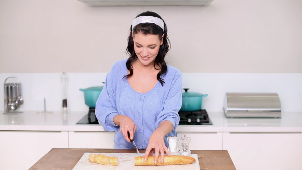 Beautiful Brunette Slicing Up A Baguette