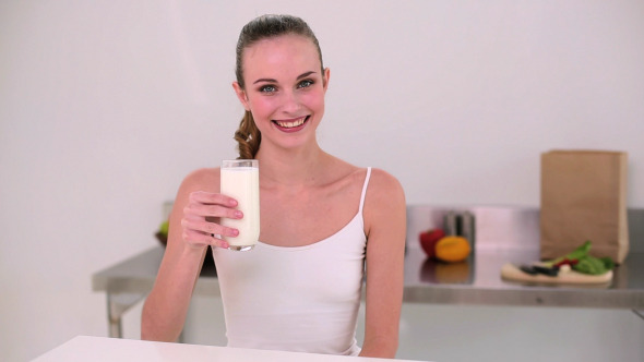 Smiling Model Drinking Glass Of Milk