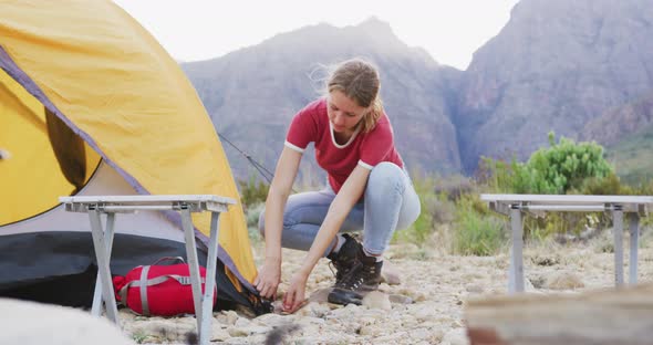 Caucasian woman setting up camping tent