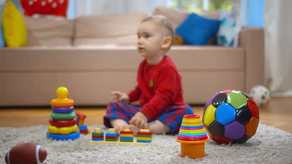 Little Kid Playing with Colorful Educational Toys on Carpet at Home
