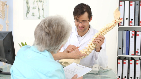Chiropractor Showing Spine Model To His Patient
