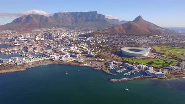 Aerial travel drone view of Cape Town, South Africa with Table Mountain and stadium.