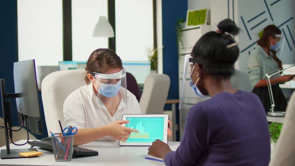 Group of Multiethnic People with Face Masks Analyzing Financial Data