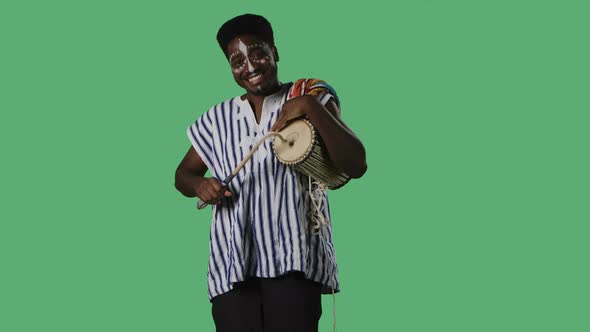 Portrait African American Man Looking at Camera and Plays African Talking Drum Yuka