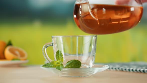 Pouring Citrus Tea in Cup Closeup