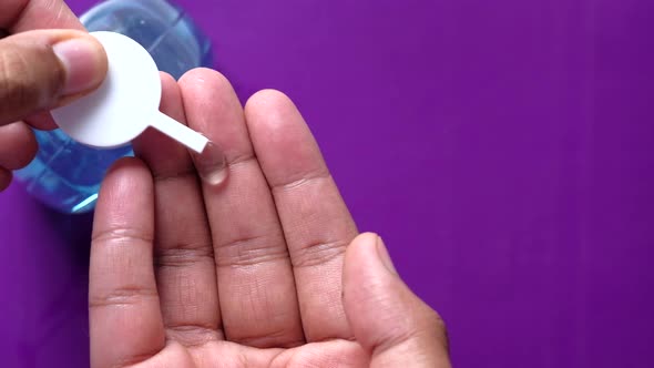 Close Up of Young Man Hand Using Sanitizer Gel for Preventing Virus 