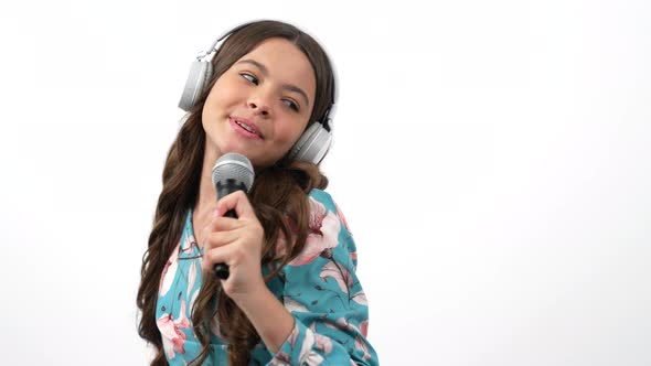 Happy Kid Singer Listen Music in Headphones and Sing in Microphone Imagine Herself Star Childhood