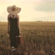Female With A Suitcase Walking In Field - VideoHive Item for Sale