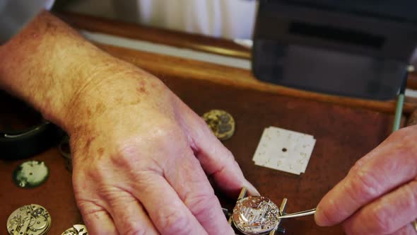 Close-up of horologist hands repairing a watch