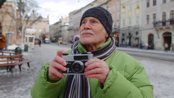 Senior Happy Man Grandfather Taking Pictures with Photo Camera Smiling Using Retro Device Outdoors
