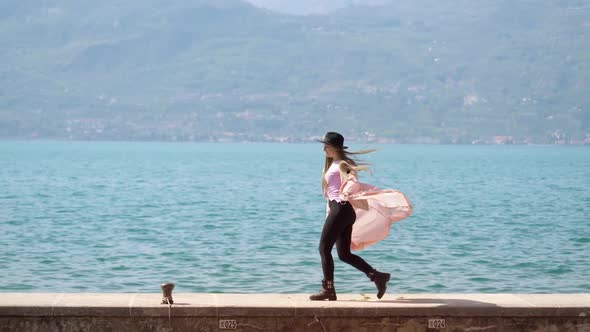 Cheerful Woman Enjoys Walking on Pier at Lake Garda Dancing