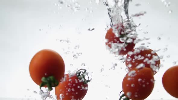 Tomatoes Falls Into Water and Make Bubbles on White Background Slow Motion for Your Project