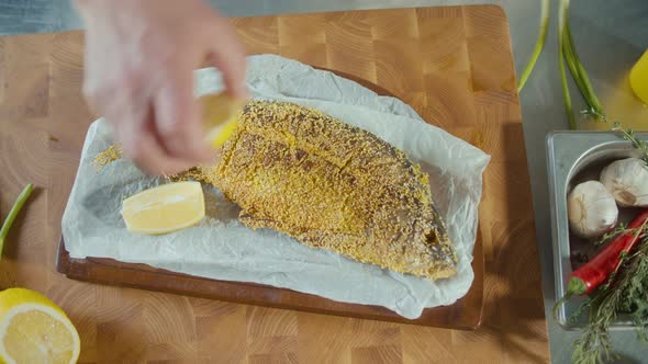 Professional Cook Stylishly Serving Batter Fried Fish on a Wooden Board