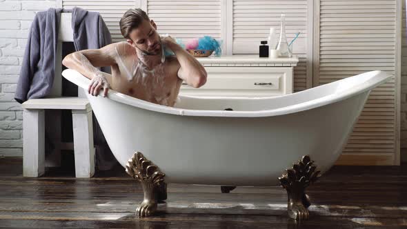 Confident Guy with Shaver in Bathroom. Young Man in Luxury Bathroom Interior