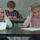 Bored Girl Sitting at Desk in School Classroom, Discussing Something with Classmate - VideoHive Item for Sale