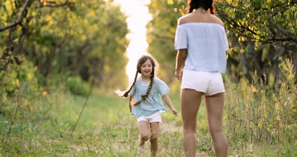 Child Running Into Mother's Hands to Hug Her