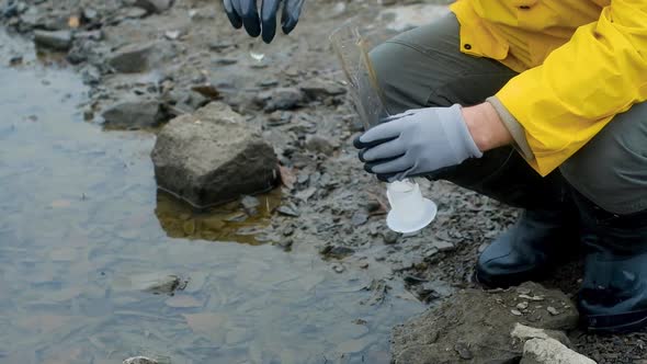 Ecology is modern. expert pours water from river into a test tube for analysis.