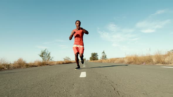 Black Man Trains Outdoors Runs Along Road and Checks His Pulse on Smartwatch and Begins to Perform