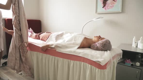 A Masseur Gives a Woman a Professional Facial Massage