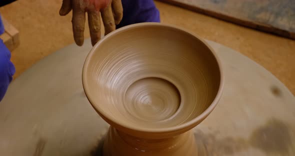 Skilled Hands of Potter Shaping the Clay on Potter Wheel and Sculpting Clay Pot Jar. Shilpagram