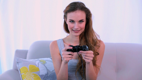 Smiling Model Playing Video Games On The Couch