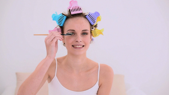 Young Model In Hair Rollers Brushing Her Eyebrows
