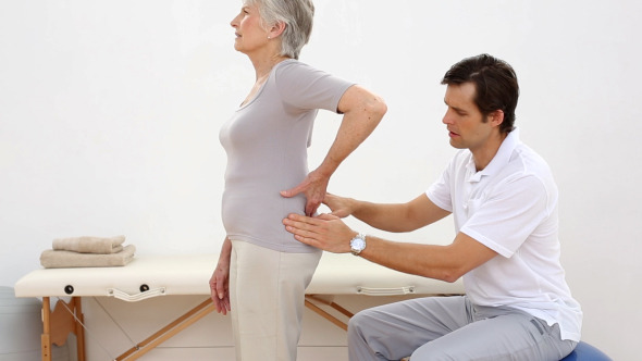 Physiotherapist Touching Senior Patients Back