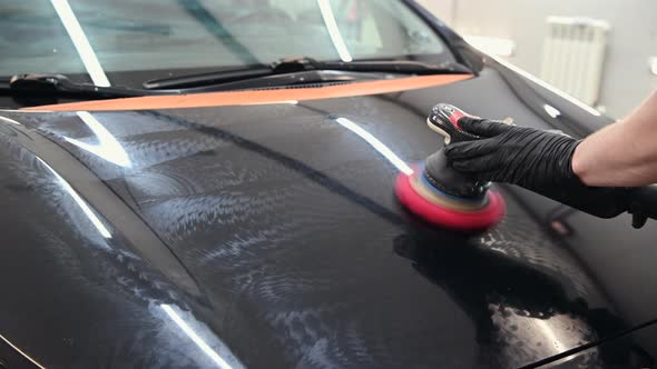 Car Polish with a Pink Grinding Disc Attached to a Polisher Machine Close Up