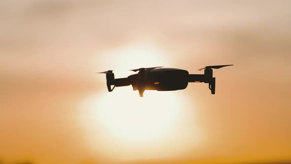 The Drone Hovers in Flight at Sunset