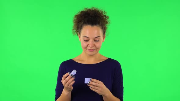 Portrait of Curly Woman Opening a Small Box with a Surprise and Is Very Disappointed with What She