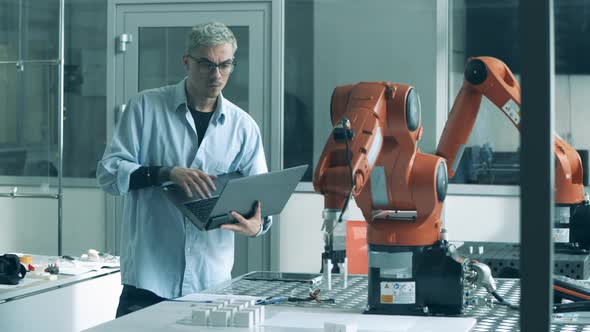 Computer Expert Is Observing a Robotic Arm Displacing Objects