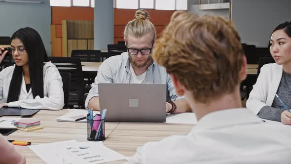 Young Diverse Colleagues Developing Productive Strategy for a New Startup Project Sitting at Table