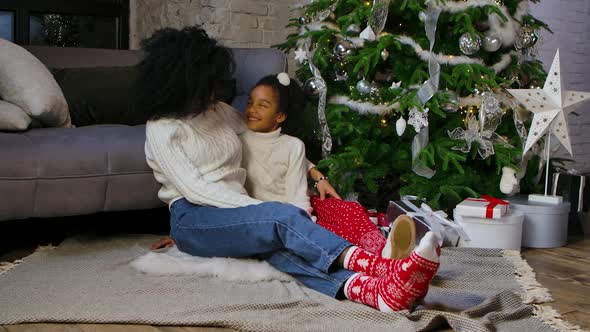 Portrait of African American Mom and Her Little Daughter Hugging and Talking Cute