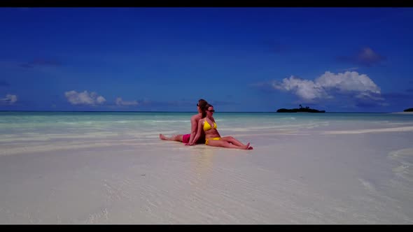 Man and woman relax on beautiful bay beach wildlife by turquoise lagoon and white sand background of