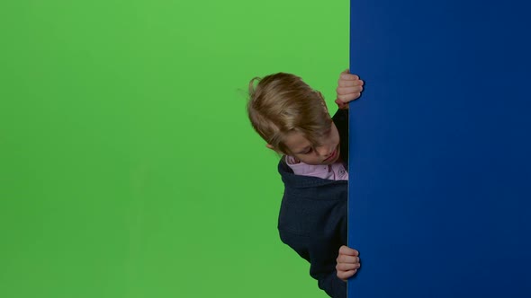 Teenager Peeks Out From Behind the Boards and Shows Like on a Green Screen