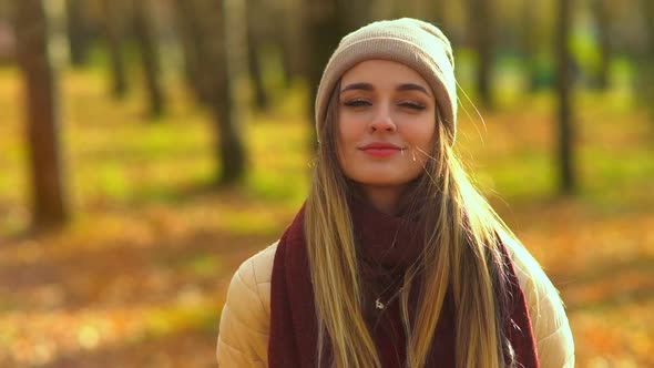 Young Attractive Girl in Autumn Park. She Looks at the Camera and Smiles, Shows Different Emotions.