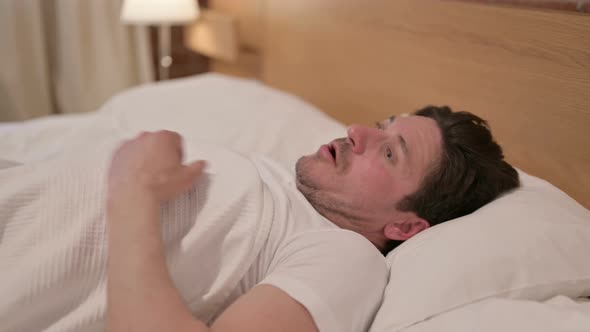 Middle Aged Man Waking up from Nightmare in Bed