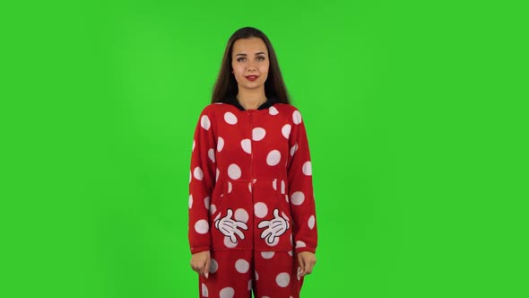 Beautiful Girl in Red Fleece Pajamas Is Standing, Spreads Out in a Smile. Green Screen